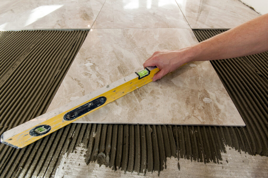ceramic tiles and tools for tiler. floor tiles installation. home improvement, renovation ceramic tile floor adhesive, mortar, level