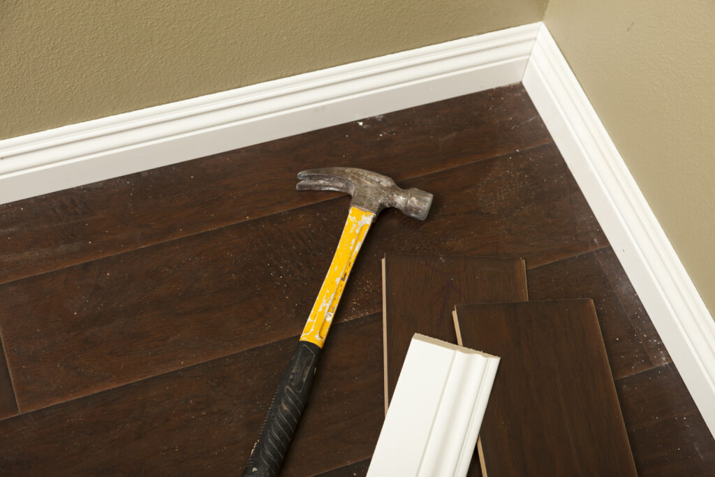hammer, laminate flooring and new baseboard molding abstract.